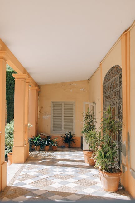 Elegant Mediterranean-style hallway with terracotta pots and lush plants.